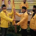 Anha (kiri) memegang panji Golkar usai terpilih kembali dalam Musda DPD Golkar Gresik X, beberapa waktu lalu. foto: SYUHUD/ BANGSAONLINE