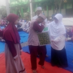 BERBAGI: Waka Kesiswaan SMK Antartika 2 simbolis menyerahkan santunan kepada anak yatim piatu, Jumat (8/6). Foto: MUSTAIN/BANGSAONLINE
