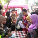 Beberapa petugas dari Dispendukcapil Kota Malang saat melayani warga hendak mengurus administrasi di stand PMR. foto: IWAN/ BANGSAONLINE