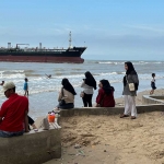 Para wisatawan saat melihat Kapal Tanker MT Abigail W yang kandas di Pantai Panduri, Desa Tasikharjo, Kecamatan Jenu, Tuban.