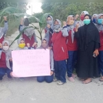 Para emak-emak dari Desa Angsanah saat melakukan aksi blokir dan tanam pohon pisang di jalan poros desa yang rusak.