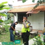 Petugas memasang garis polisi di kos-kosan tempat korban tinggal. foto: RONY S/ BANGSAONLINE