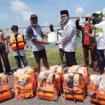 ANTISIPASI LAKA LAUT: Bambang Haryo Soekartono (BHS) memberikan jaket pelampung kepada nelayan Sedati, Senin (20/4). foto: MUSTAIN/ BANGSAONLINE