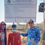 Camat Balongpanggang, M. Jusuf Ansyori berfoto membelakangi papan nama pembangunan tahap 1 proyek Islamic Center. foto: ist.