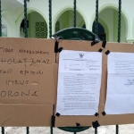 Pemberitahuan tidak adanya sholat Jumat di Masjid Tiban Kota Probolinggo yang dipasang di pagar.