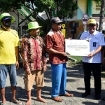 Direktur Utama Petrokimia Gresik, Dwi Satriyo Annurogo (dua dari kanan) saat menyerahkan bantuan kepada tukang becak. Foto: Ist