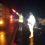 Anggota Polsek Sawoo saat mengatur lalin jalan raya Ponorogo-Trenggalek, akibat plengsengan longsor.
