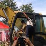 Bupati Ipong saat mengendalikan buldozer untuk membongkar eks lokalisasi Kedung Banteng. foto: BANGSAONLINE