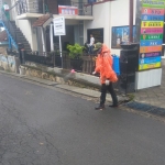 Relawan FPRB tengah melakukan penyemprotan disinfektan di depan Balai Desa Giripurno, Bumiaji, Kota Batu.