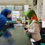 Petugas dari BPJS Kesehatan saat melayani salah satu pasien.