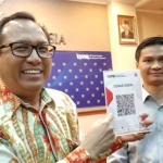Kepala Bank Indonesia Perwakilan Kediri Musni Hardi Kusuma Atmaja menunukkan salah satu QR yang digunakan untuk uji coba. foto: ARIF KURNIAWAN/ BANGSAONLINE