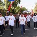 Wali Kota Kediri Abdullah Abu Bakar (tiga dari kiri) dan Ketua PWI Jatim Lutfi Hakim (empat dari kiri bersama anggota Forkompinda Kota Kediri saat mengikuti jalan sehat untuk memperingati HPN ke 77 PWI Jatim. Foto: Ist.