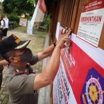 Petugas Satpol PP Kota Madiun memasang peringatan di pintu The Forest Cafe.