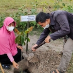 Ketua Yayasan Hijau Daun Mandiri Kediri, Endang Pertiwi, dibantu salah satu relawan saat akan menanam pohon di area Sumber Banteng. foto: MUJI HARJITA/ BANGSAONLINE
