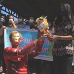Iron Man Kampung Tangguh RW 04 saat memberi bunga kepada seorang mahasiswi demi memberikan support dan selamat atas kesembuhannya. (foto: ist).