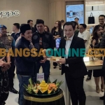 Gus Iqdam saat menyerahkan potongan tumpeng kepada Chief Marketing Officer OPPO Indonesia, Patrick Owen. Foto: MUJI HARJITA/ BANGSAONLINE