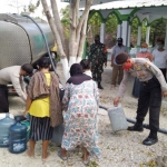 Petugas sedang membagikan air bersih ke warga.
