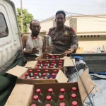 Petugas menunjukkan puluhan botol miras yang disita. foto: SOFFAN/ BANGSAONLINE
