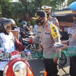 Kapolres Kediri Kota AKBP Miko Indrayana, saat memberikan masker kepada pengguna jalan. foto: MUJI HARJITA/ BANGSAONLINE