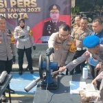 Kapolres Kediri Kota AKBP Teddy Chandra saat memusnahkan knalpot brong dengan cara dipotong menggunakan gergaji mesin. Foto: MUJI HARJITA/ BANGSAONLINE