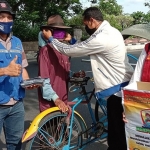 Petugas saat memakaikan masker kepada warga. foto: ist.