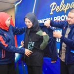 Gubernur Jatim, Khofifah Indar Parawansa (kiri) memasangkan jaket untuk kontingen Jatim bersama Kepala Dinas Pendidikan Jatim, Aries Agung Paewai (kanan). (Ist)