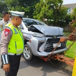 anggota kepolisian saat melakukan pengecekan terhadap salah satu mobil yang terlibat kecelakan beruntun di KM 748/B ruas Tol Sidoarjo arah Waru, Jumat (15/12/2023).