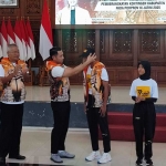 Bupati Aditya Halindra Faridzky memasangkan topi kepada salah satu atlet Kontingen Tuban yang akan berlaga di Porprov IX Jatim 2025.