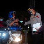 Kapolresta Sidoarjo, Kombes Pol Kusumo Wahyu Bintoro, saat membagikan masker kepada pengendara yang melintas.