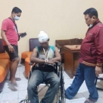 Tersangka duduk di kursi roda saat hendak menjalani pemeriksaan.