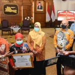 Gubernur Jawa Timur, Khofifah Indar Parawansa, saat memberikan piagam penghargaan kepada atlet wushu, Utiqo Romadlona Ummi Auna.