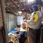 Anggota Bhabinkamtibmas saat membagikan sembako secara door to door. (foto: ist.)