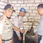 Petugas saat melakukan penggerebekan rumah yang digunakan untuk memproduksi arak di Desa Sambongrejo.