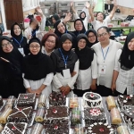 Kasi Pelatihan Kerja Disnaker Kota Malang Tjuratna dan Instruktur pelatihan keterampilan Nissa Hansawati bersama para peserta pose bareng dengan hasil karya kuenya.