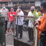 Sejumlah petugas saat berada di depan rumah korban tewas gantung diri di Kota Blitar. foto: AKINA/ BANGSAONLINE