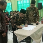 Kepala Kantor Kemenag Lamongan Muhlisin Mufa didampingi Kasi Pendma Banjir Sidomulyo saat penandatanganan MoU dengan BAN PDM Provinsi Jawa Timur.