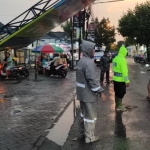 Petugas saat mengatur lalu lintas di depan lokasi rubuhnya papan reklame