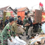 Para prajurit TNI sedang membantu warga membersihkan puing-puing pasca hempasan angin puting beliung disertai hujan yang menerjang wilayah Kecamatan Waru Sidoarjo, Rabu (22/11) lalu.