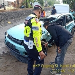 Kondisi mobil sedan Mazda nopol P 1786 GS tampak ringsek usai tertabrak kereta api saat menyebrang di perlintasan kereta api tak berpalang pintu di kawasan Desa Kramat Jegu, Kecamatan Taman, Sidoarjo, Rabu (17/2/2021). foto: Polresta Sidoarjo