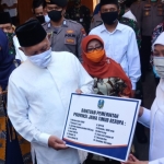 Gubernur Jawa Timur Khofifah Indar Parawansa secara simbolik menyerahkan bantuan perangkat alat penegakan protokol kesehatan anticovid-19 kepada Pesantren Tebuireng yang diterima KH Abdul Hakim Mahfudz (Gus Kikin), pengasuh Pesantren Tebuireng Jombang Jawa Timur. foto: ist/ bangsaonline.com 