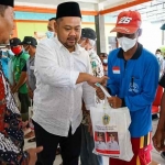 Bupati Gresik, Fandi Akhmad Yani menyerahkan bansos kepada nelayan di Desa Ngimboh, Kecamatan Ujungpangkah. Foto: SYUHUD/ BANGSAONLINE