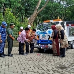 Bupati Jombang Warsubi saat melaunching tim mandor jalan dan normalisasi saluran ditandai dengan penyiraman air kembang pada armada yang digunakan. Foto: AAN AMRULLOH/ BANGSAONLINE