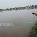 Salah satu petani menunjukkan sawahnya yang terendam banjir. foto: rony suhartomo/ BANGSAONLINE