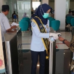 
Petugas dari Kantor Imigrasi Kediri, saat memberikan cairan hand sanitizer kepada salah satu pemohon paspor. 