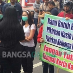 Sejumlah pemandu lagu nampak ikut berorasi sambil membentangkan poster berisi berbagai tulisan.