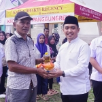 Wali Kota Pasuruan, Adi Wibowo, saat menyerahkan paket sembako murah kepada salah satu warga yang berbelanja.