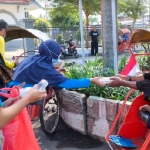 Relawan YPD Aku Bisa, saat bagi-bagi nasi bungkus kepada abang becak di depan Stasiun Kota Kediri. foto: Muji Harjita/ BANGSAONLINE.com 