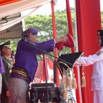 Wali Kota Kediri Abdullah Abu Bakar saat meletakkan bendera merah putih ke nampan yang dipegang paskibra pembawa bendera. Foto: Ist.