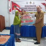 Kepala Desa Geger, Samsudin, saat memberikan bantuan kepada warga.