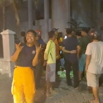 Salah seorang petugas tampak berpose dengan latar belakang eks kantor PN yang terbakar. foto: ist.